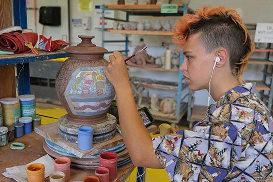 woman painting a ceramic vase